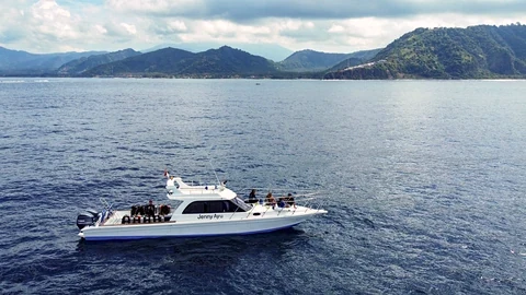 Side view of Jenny Ayu with the Bali coastline in the background