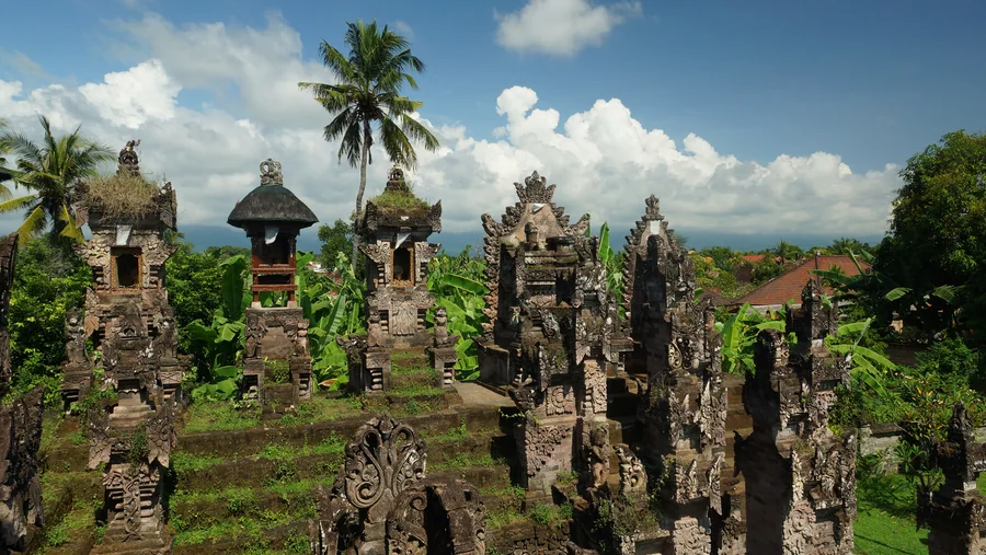 Ornate Balinese shrines among palms and tropical plants