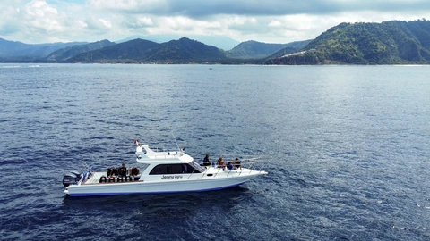 Side view of Jenny Ayu with the Bali coastline in the background